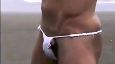 Asian bodybuilder barely covered at the beach