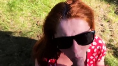 Kinky redhead with big tits gives a blowjob outdoors